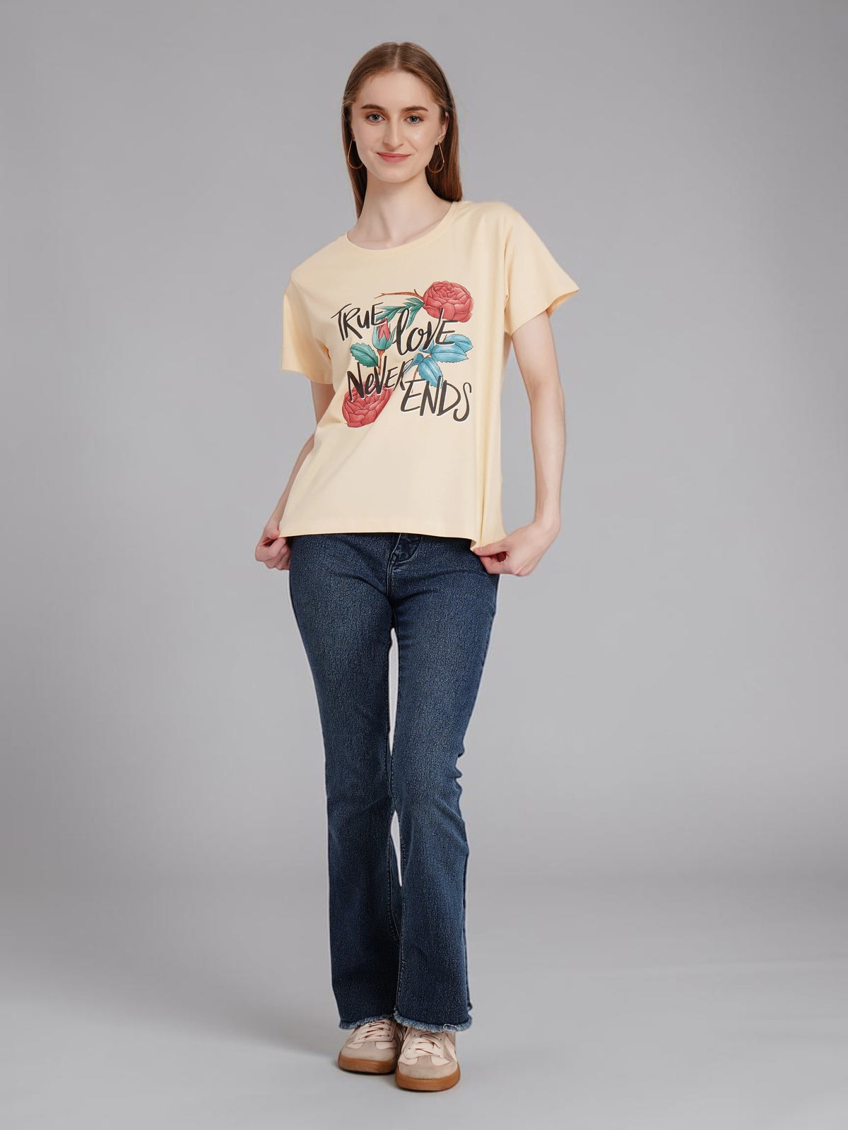 enaay.com beige cotton crew-neck t-shirt with True Love Never Ends floral graphic worn by a model with blue jeans