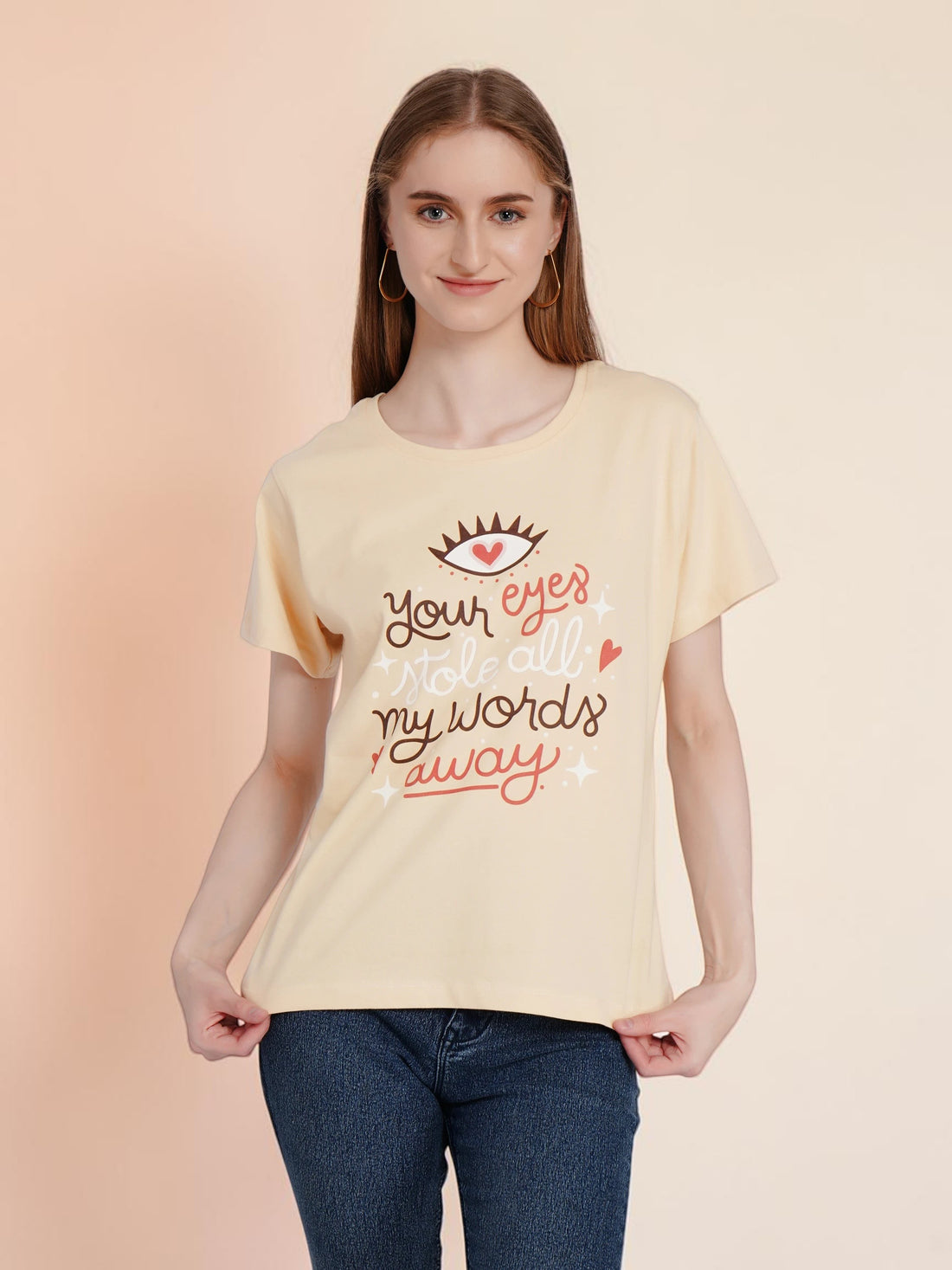 Woman wearing an enaay.com light beige cotton t-shirt with a romantic eye and heart graphic print