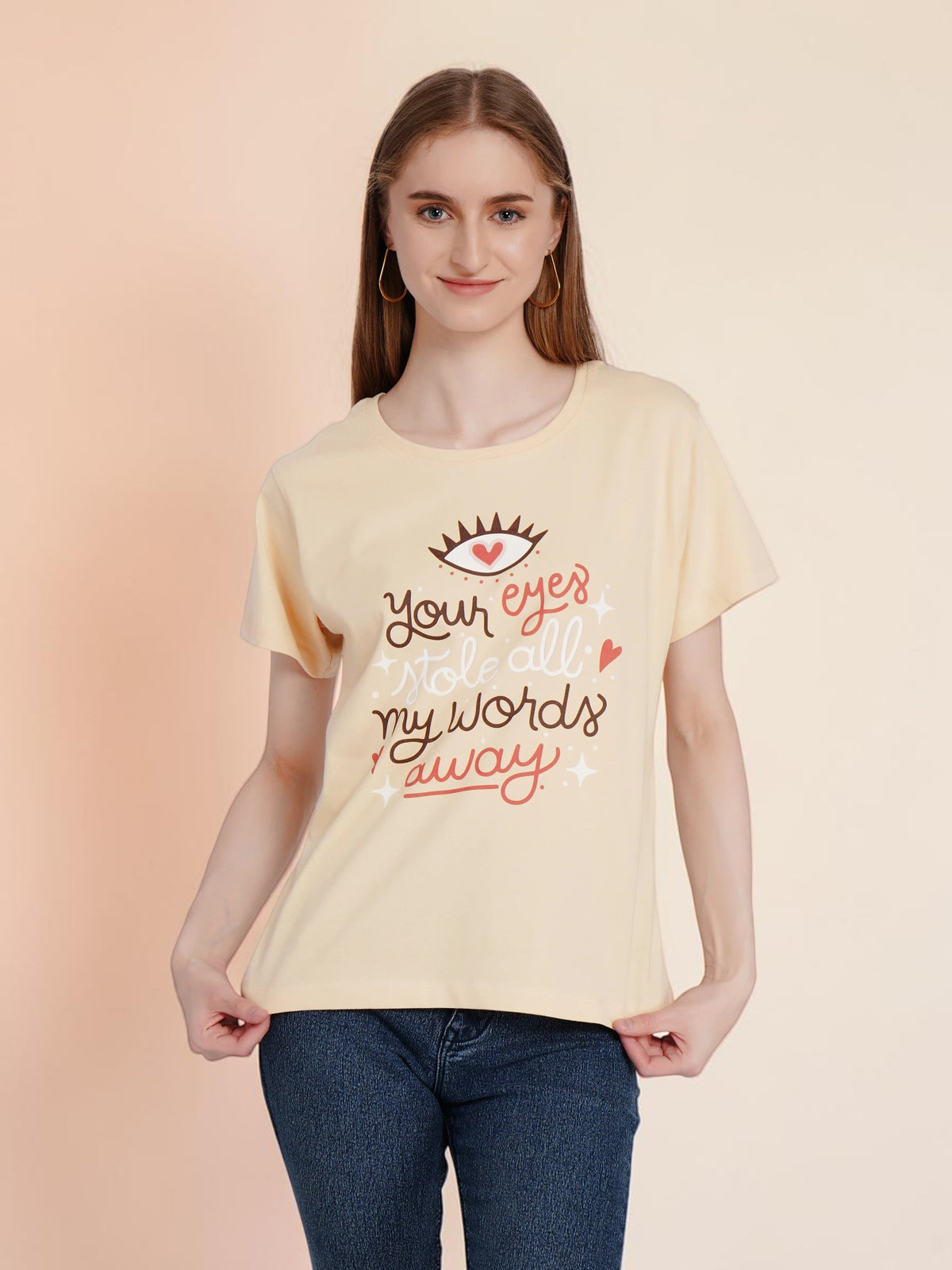 Woman wearing an enaay.com light beige cotton t-shirt with a romantic eye and heart graphic print