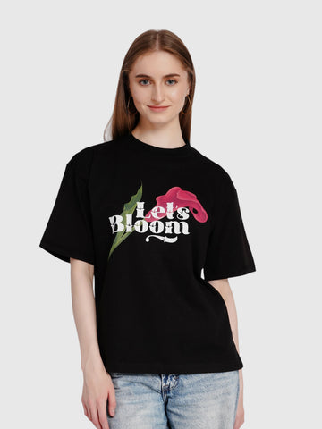 enaay.com black oversized cotton t-shirt featuring a Let's Bloom floral graphic worn by a woman
