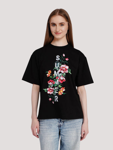 Model wearing an enaay.com black oversized cotton t-shirt with a floral print and vertical summer text graphic