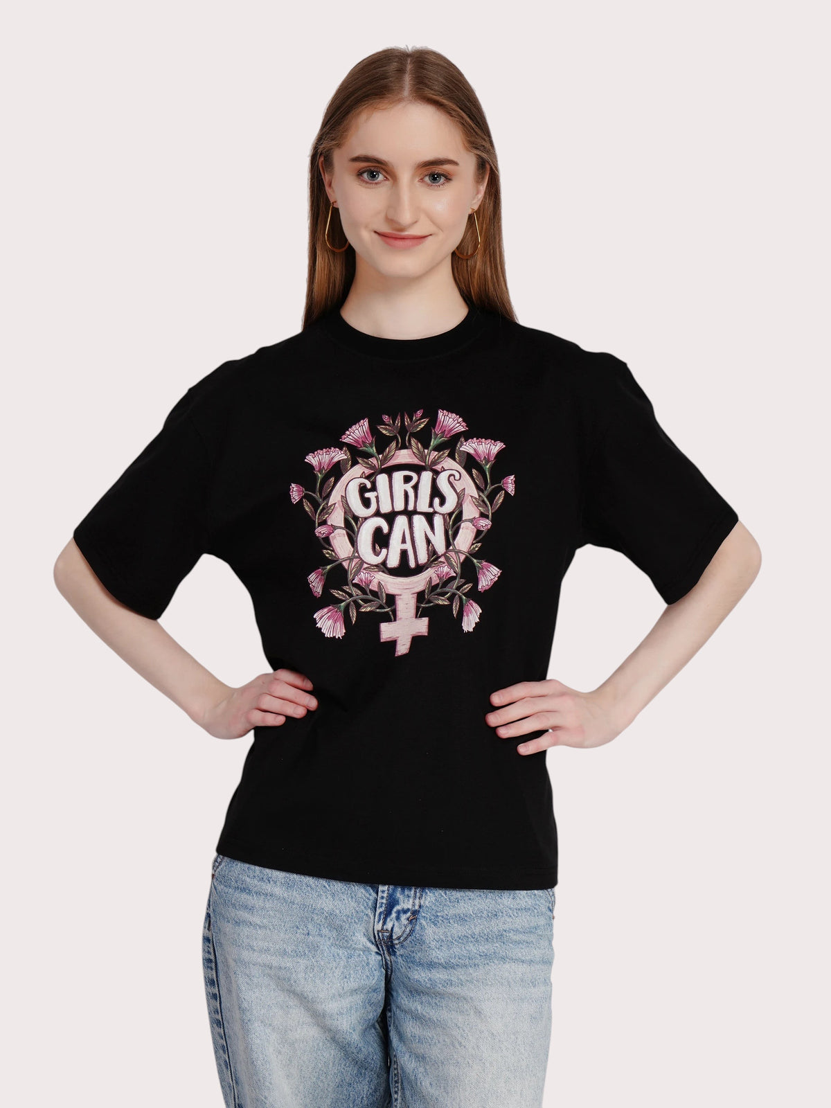 Model wearing an enaay.com black oversized cotton t-shirt with a floral Girls Can graphic print and round neckline.