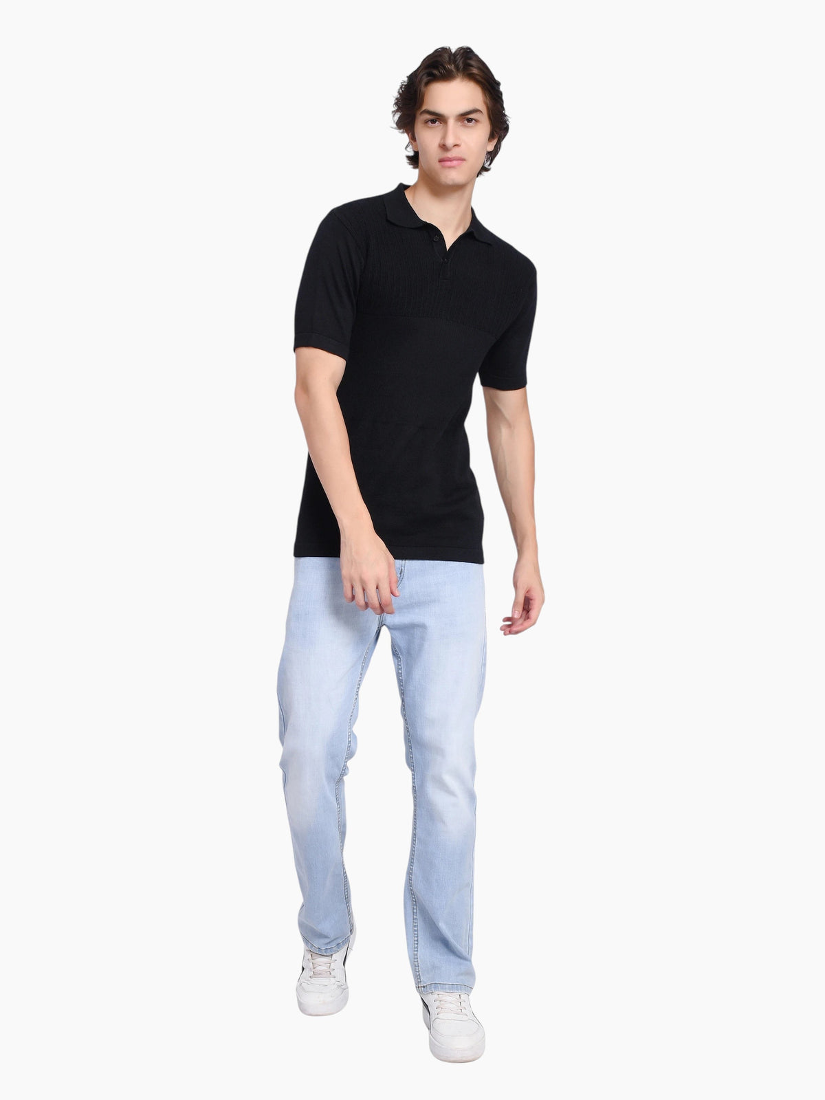 A man wearing an enaay.com black pure cotton knitted polo shirt with a classic collar and light blue denim jeans.
