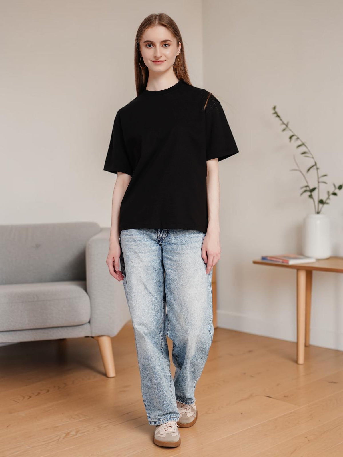 Model wearing an enaay.com black oversized premium cotton t-shirt with drop shoulders and light wash denim jeans