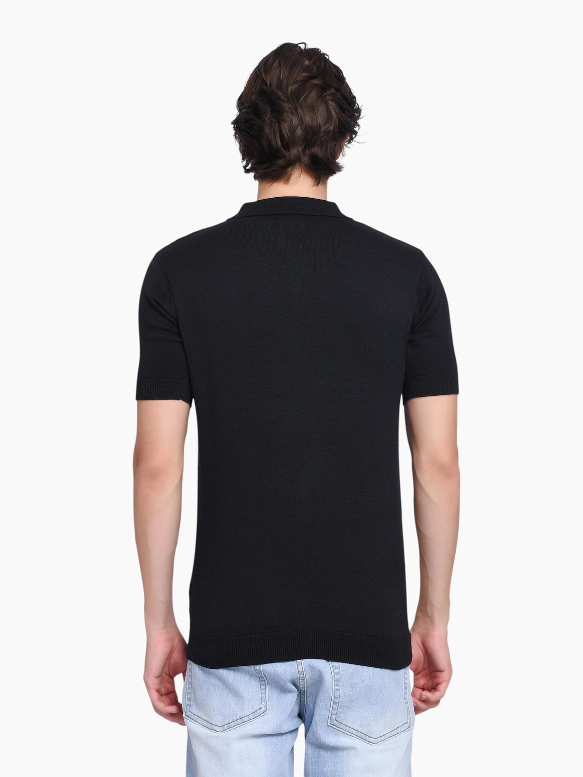 Back view of a man wearing an enaay.com black oversized crew-neck t-shirt with short sleeves and a ribbed collar.
