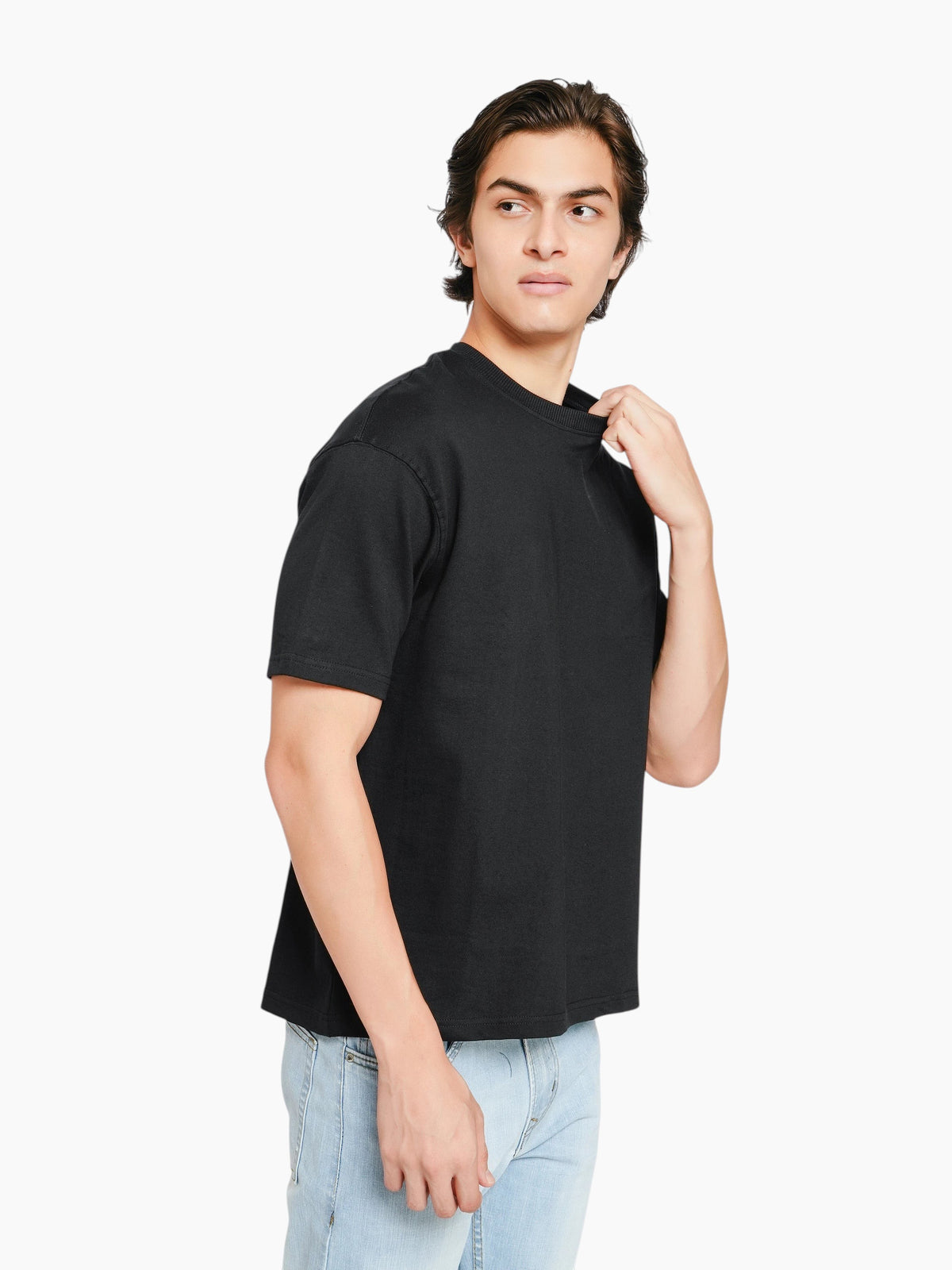 Model wearing an enaay.com black oversized crew-neck t-shirt with dropped shoulders and a relaxed, boxy fit.