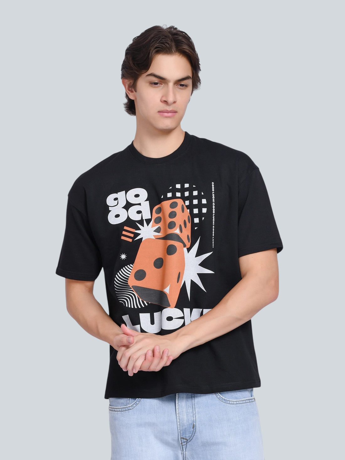 Model wearing an enaay.com black oversized t-shirt with a retro orange dice and Good Luck graphic print