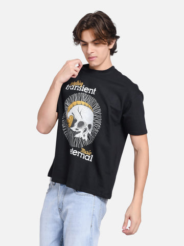 Model wearing an enaay.com black oversized crew-neck t-shirt with a skull and gold headphones graphic print.