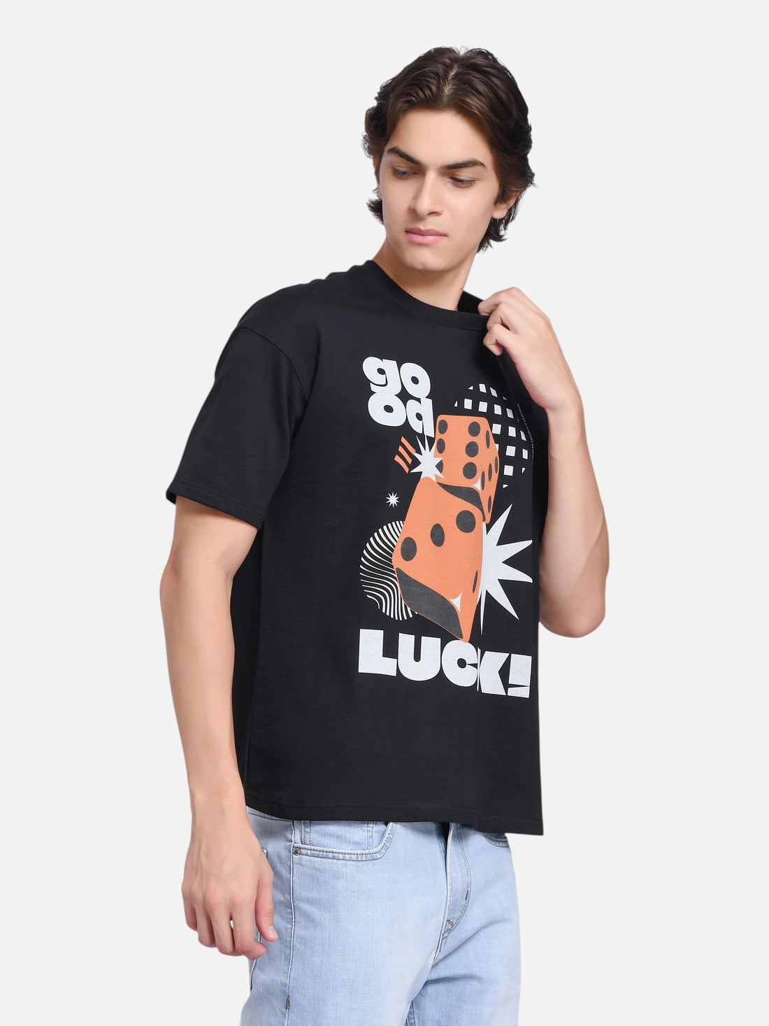 Model wearing an enaay.com black oversized t-shirt with a retro orange dice and Good Luck graphic print