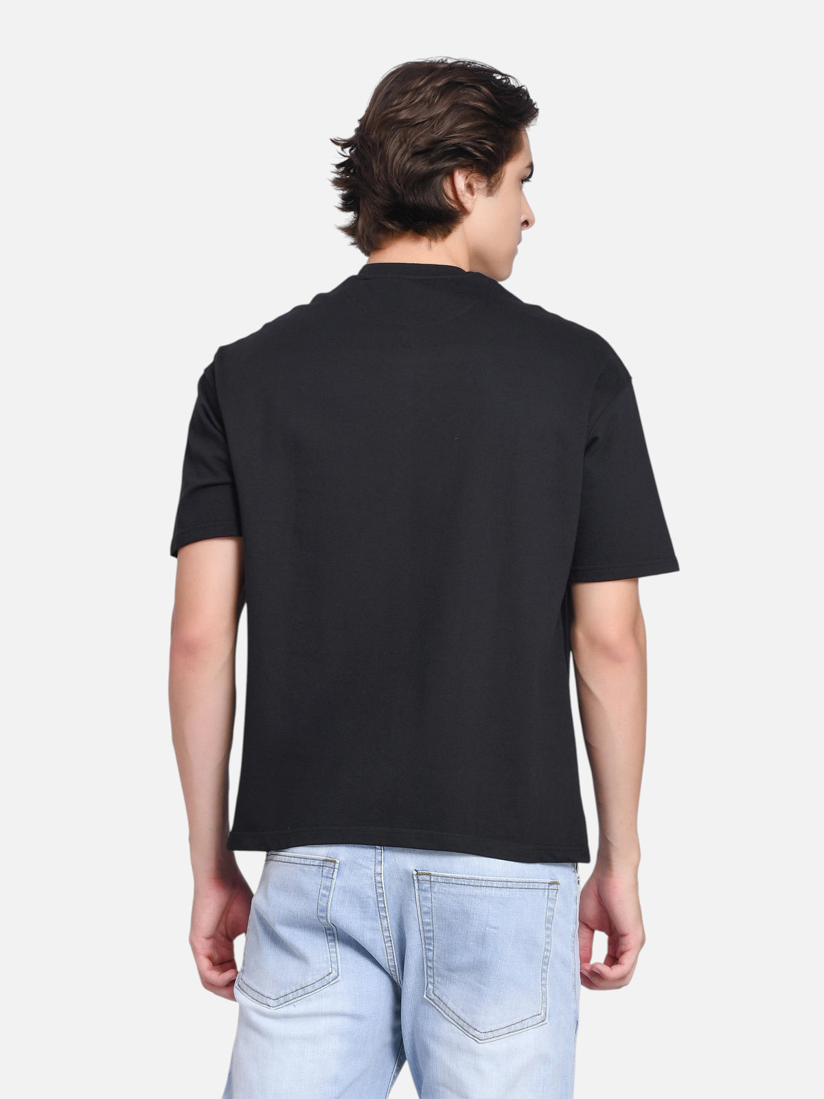 enaay.com men's black oversized t-shirt with a clean plain back, worn by a model with light blue denim jeans