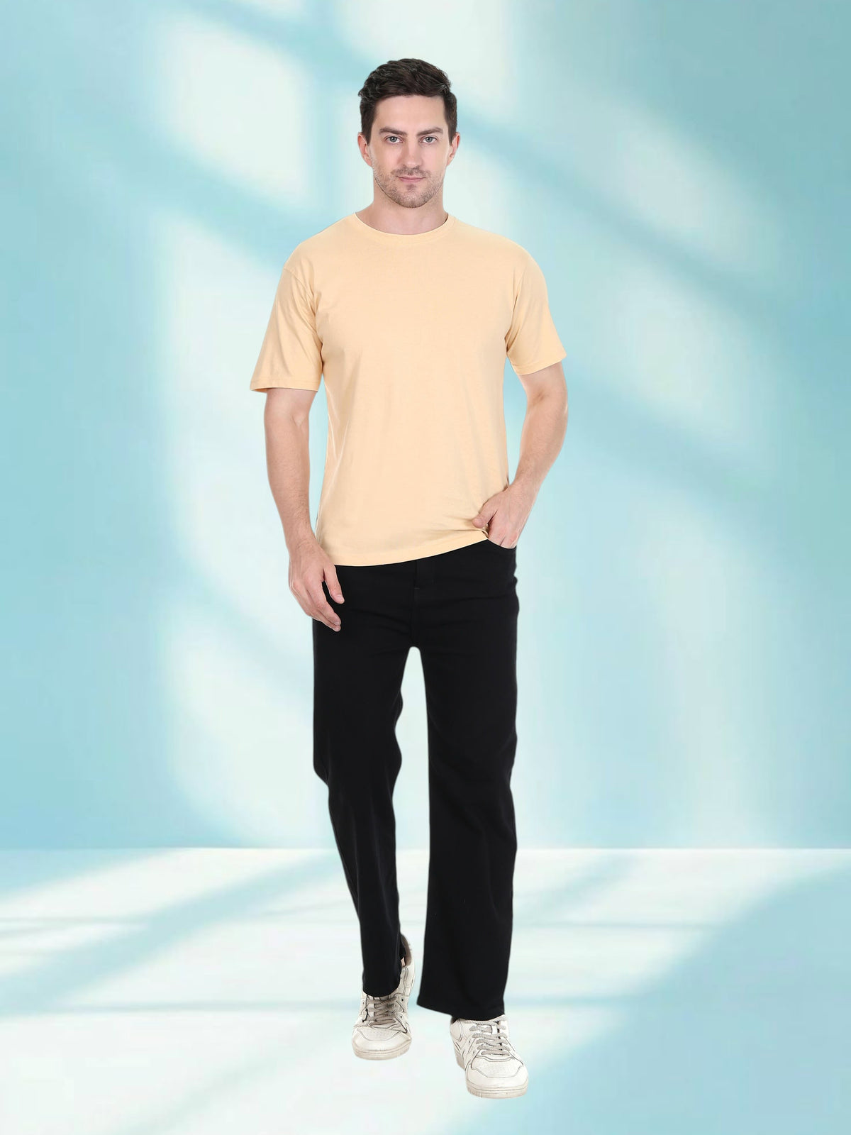 Model wearing an enaay.com camel solid premium cotton crew neck t-shirt with black trousers against a blue background.