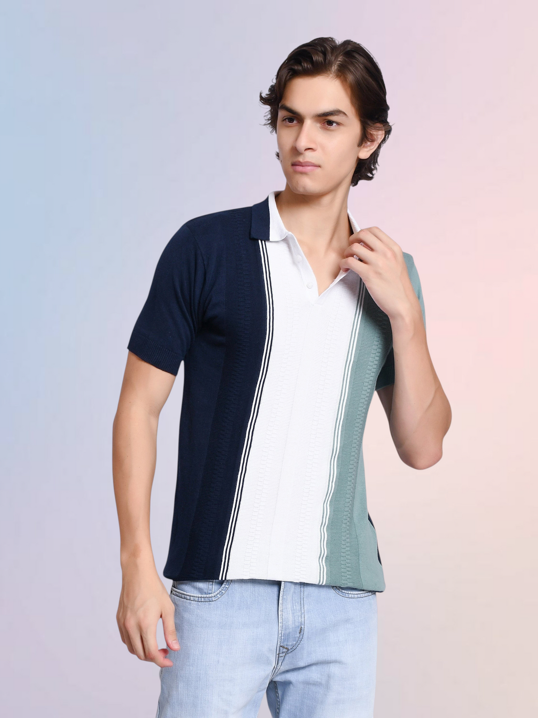 A model wearing an enaay.com navy, white, and sage green colorblock knit polo shirt with vertical pinstripe details.