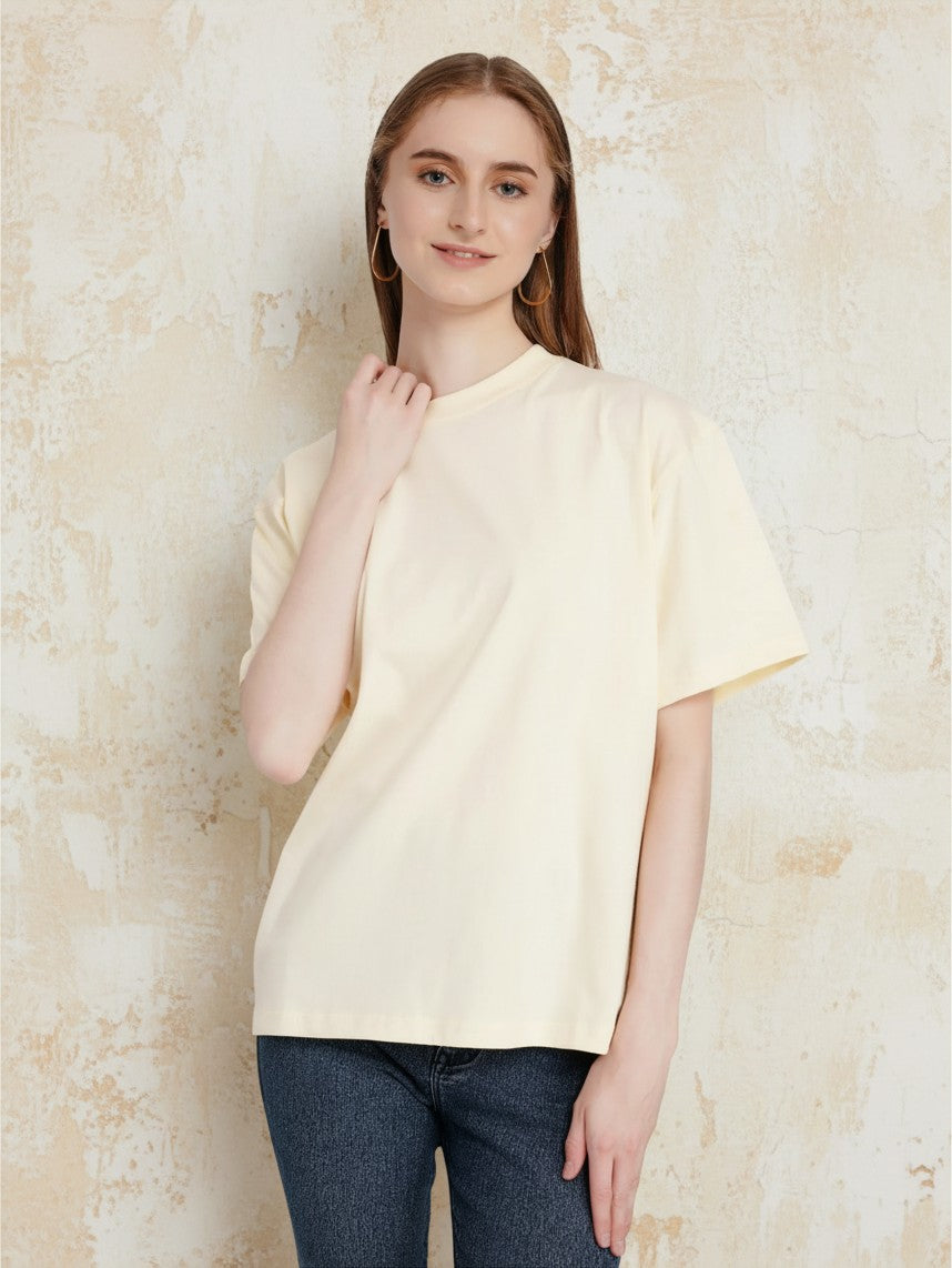 Model wearing an enaay.com light cream loose fit cotton t-shirt with drop shoulders and a round neck
