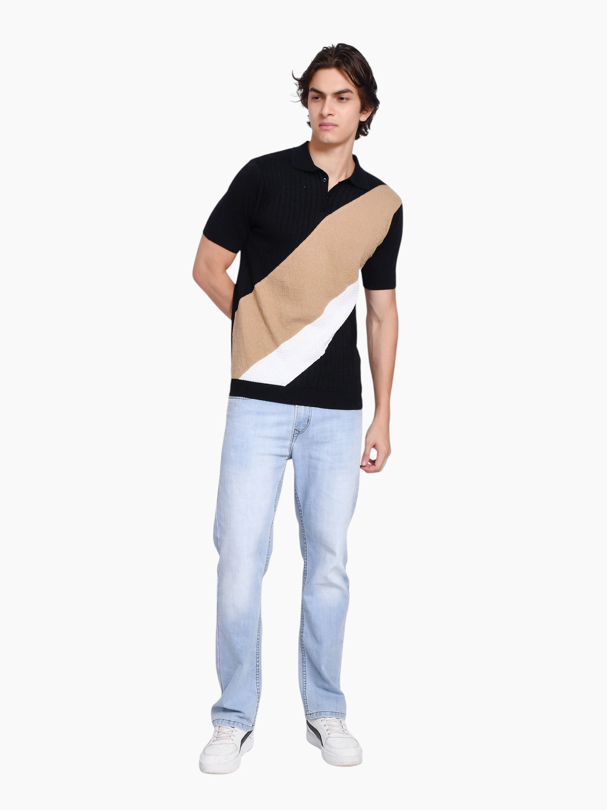 Model wearing enaay.com black, beige, and white diagonal color-block knit polo shirt with light wash jeans