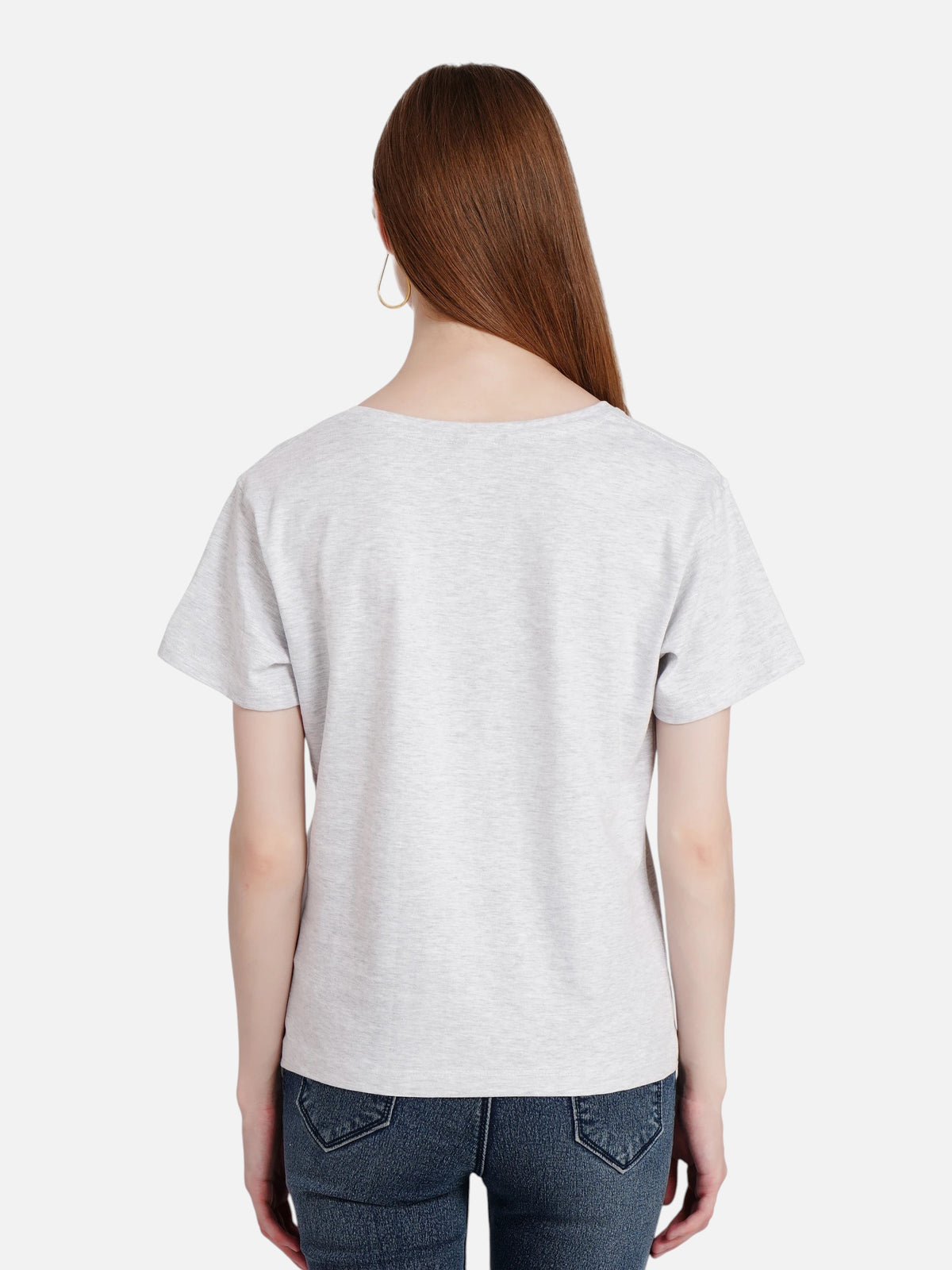 Back view of a woman wearing an enaay.com grey melange cotton round neck t-shirt with dark jeans