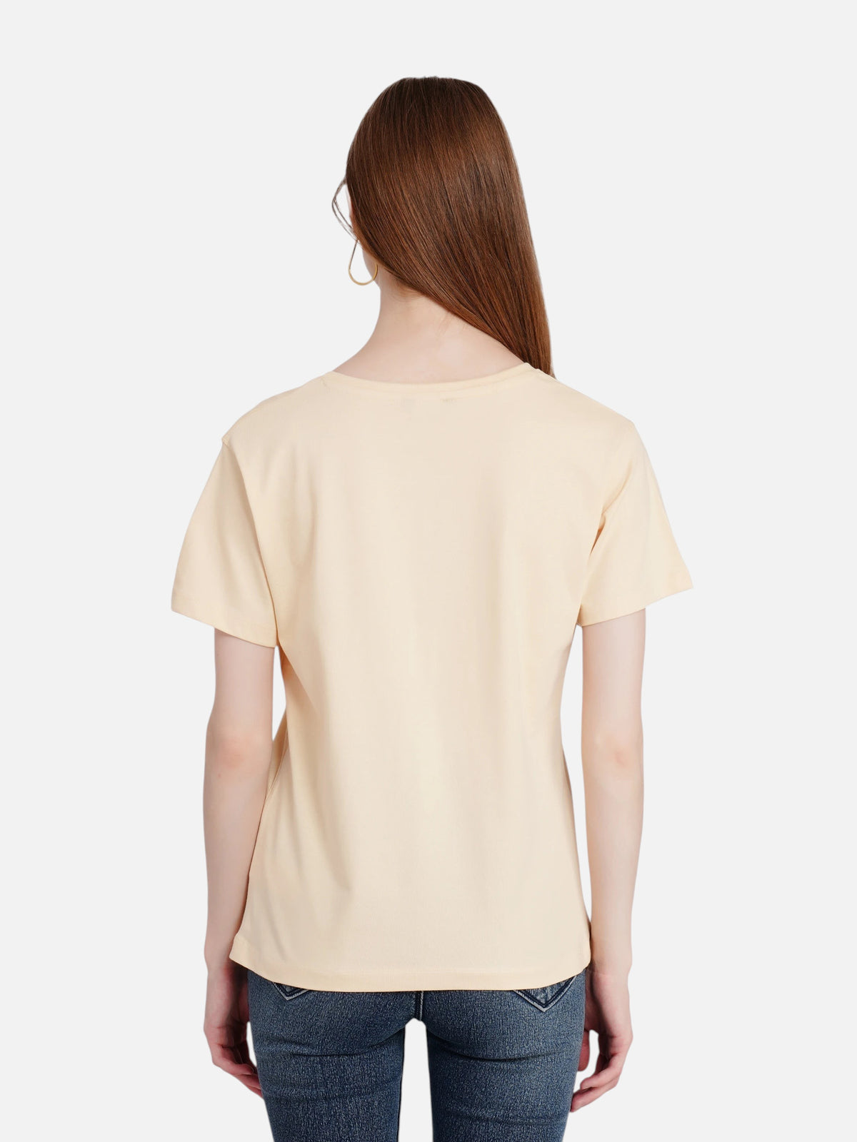 Back view of a woman wearing an enaay.com light beige premium cotton short sleeve round neck t-shirt with blue jeans