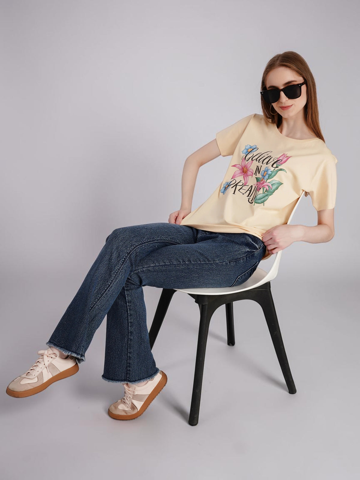 Model wearing enaay.com light beige cotton t-shirt with Believe In Dreams floral graphic and sunglasses