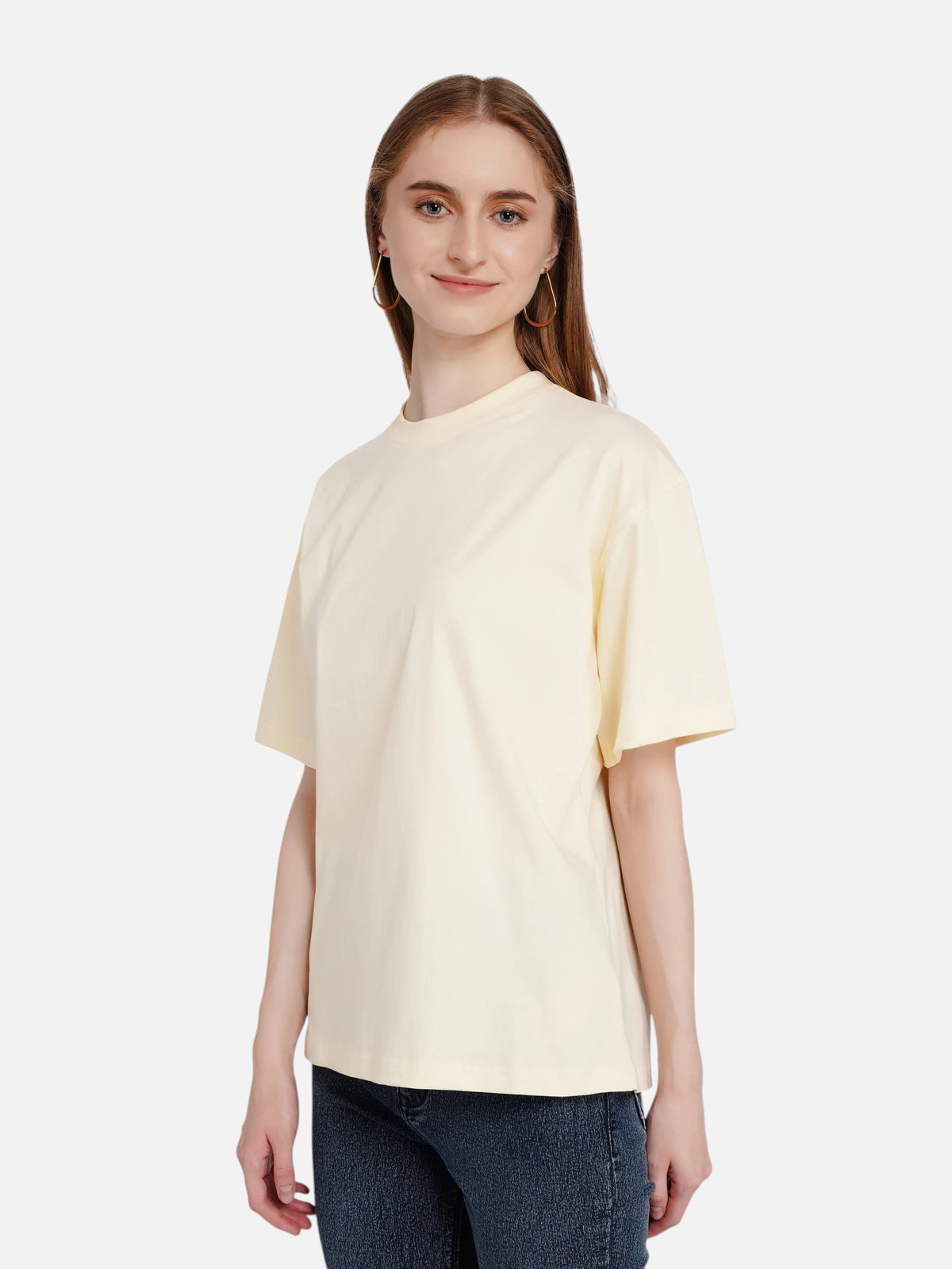 Model wearing an enaay.com light cream loose fit cotton t-shirt with drop shoulders and a crew neck.