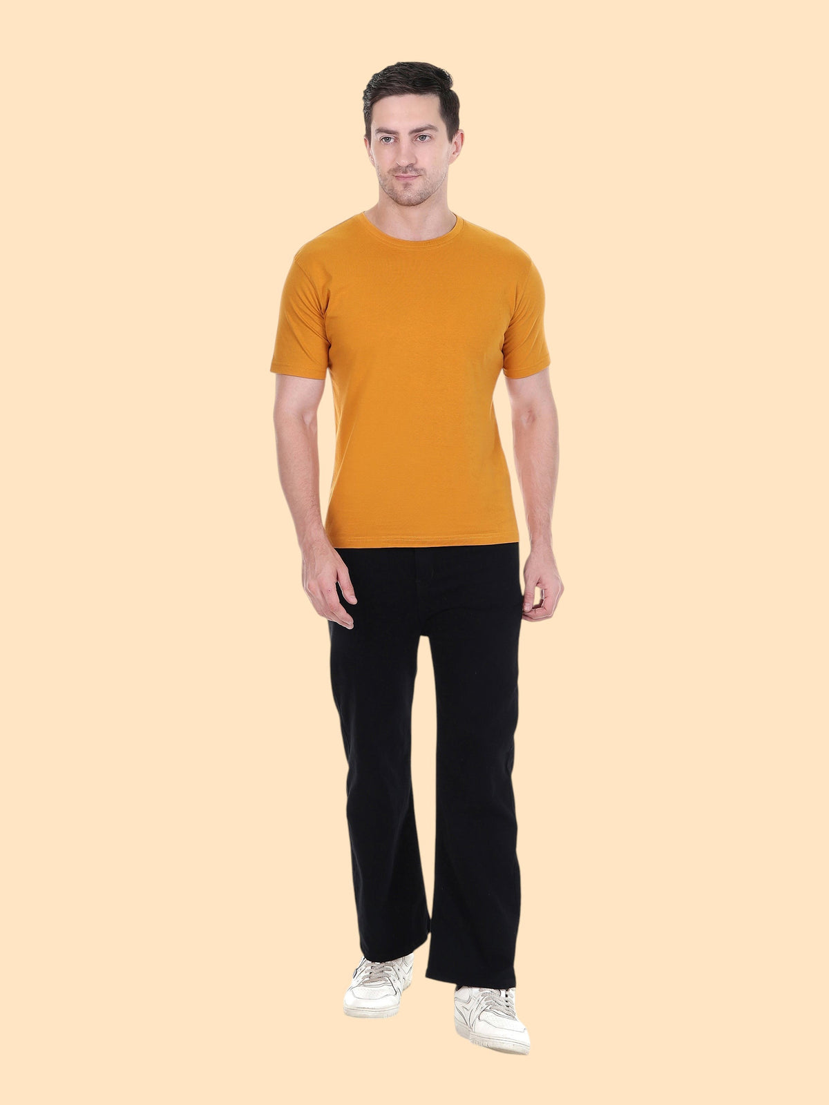 Model wearing an enaay.com mustard yellow round neck t-shirt with black trousers and white sneakers