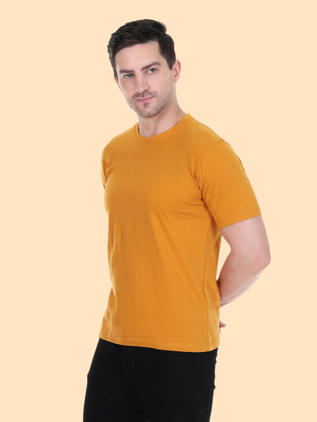 A man wearing an enaay.com mustard yellow slim fit round neck t-shirt with short sleeves against a light background.
