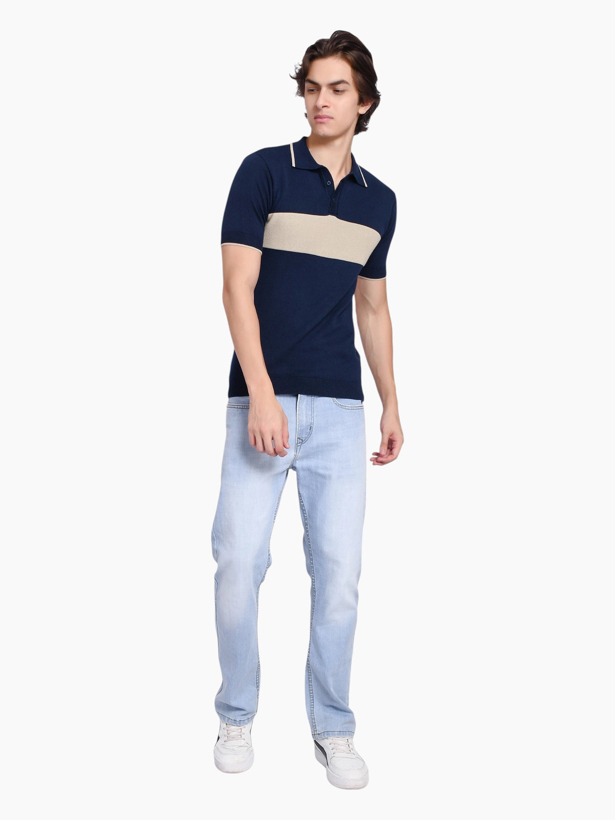 Model wearing an enaay.com navy cotton knit polo with a beige chest stripe, tipped collar, and light blue jeans.