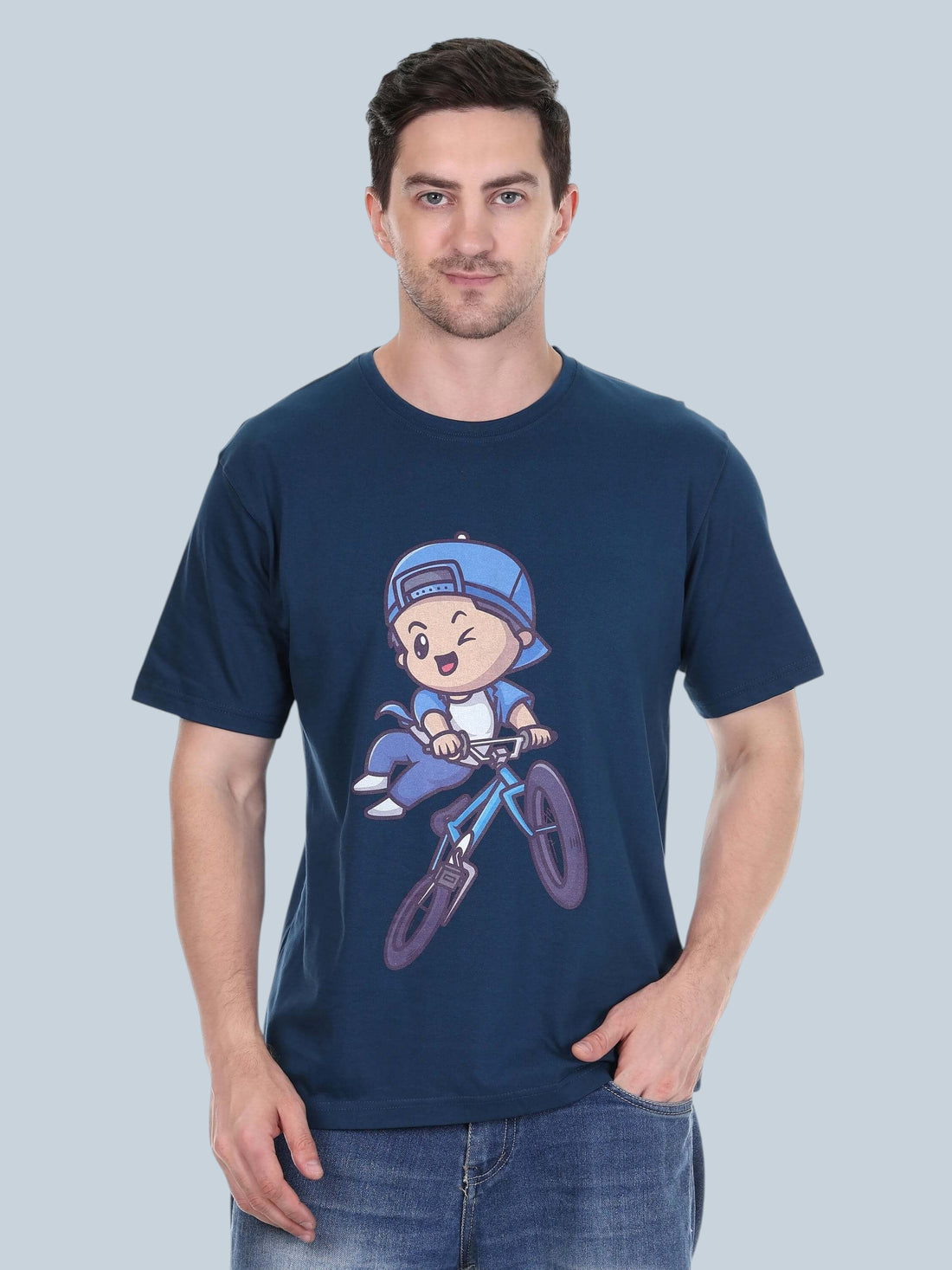 Model wearing an enaay.com navy blue cotton t-shirt featuring a playful cartoon character riding a bicycle