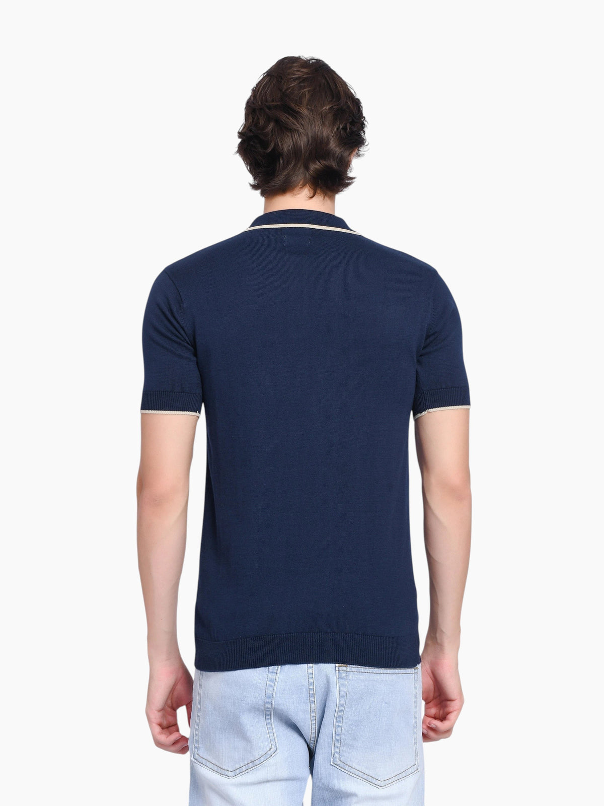 Back view of a man wearing an enaay.com navy blue cotton knit polo shirt with beige tipped collar and sleeve cuffs.