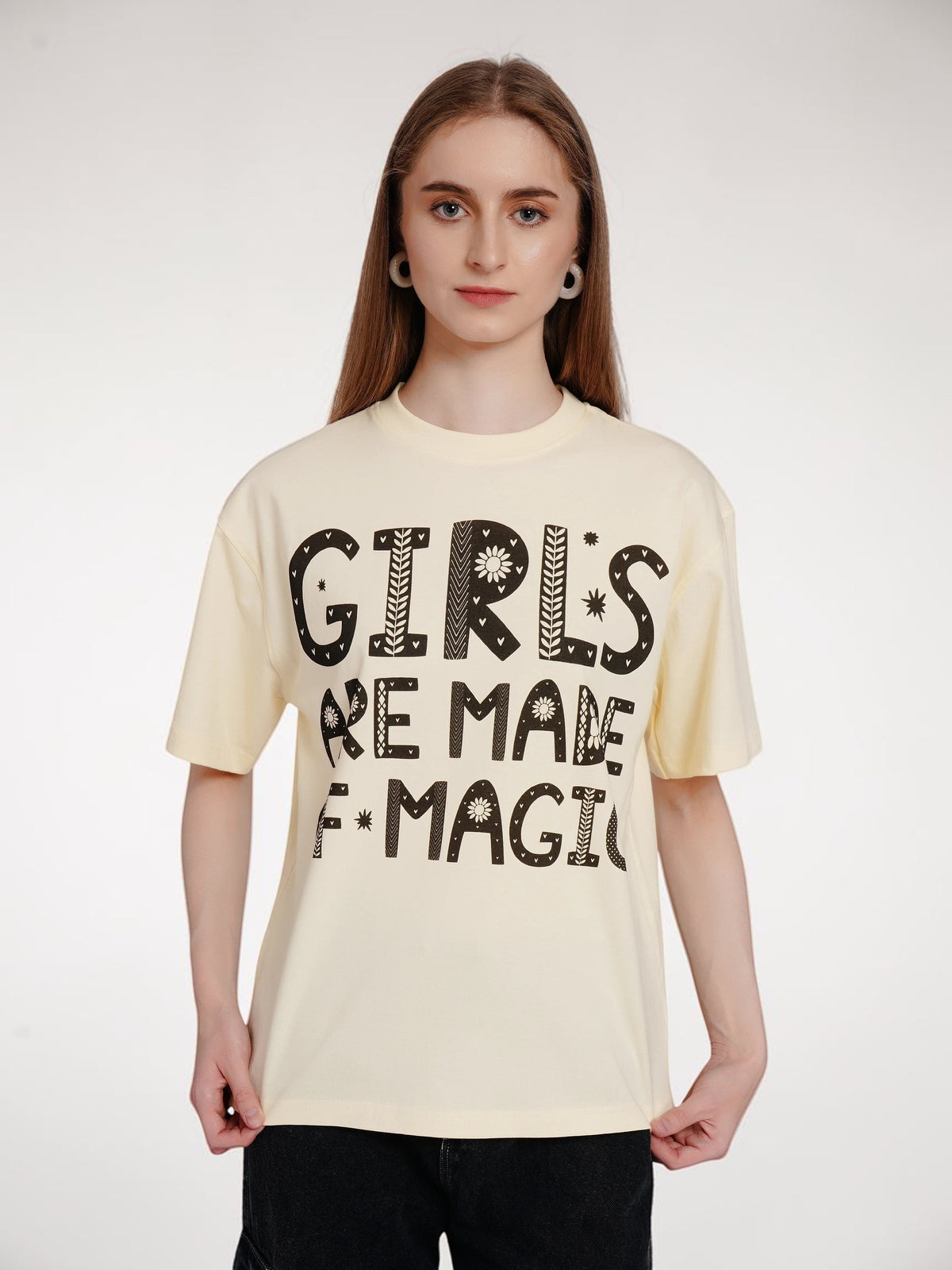 Model wearing an enaay.com off-white oversized cotton t-shirt with a black folk-art graphic print on the front.