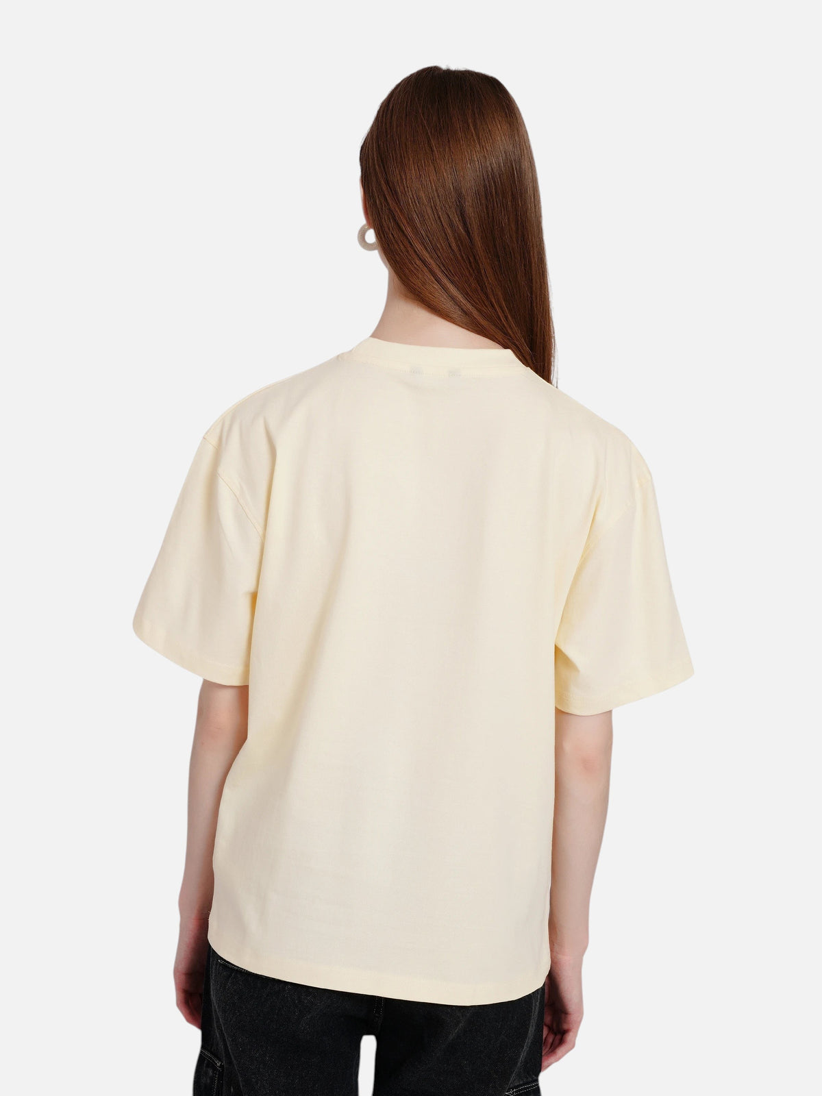 Back view of a woman wearing an enaay.com off-white oversized cotton crew neck t-shirt with short sleeves.