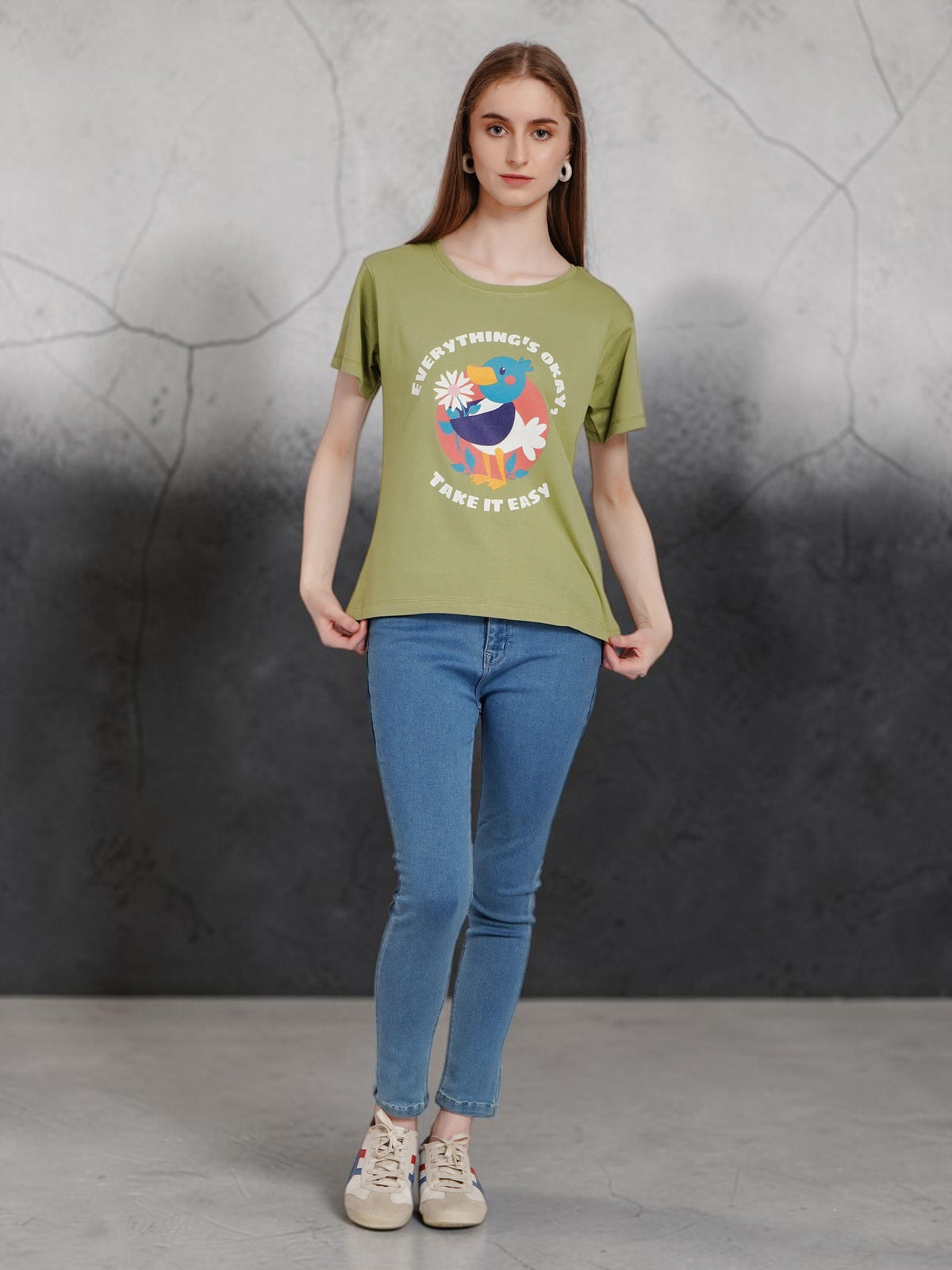 enaay.com olive green cotton t-shirt with a retro toucan graphic print worn by a model with blue jeans