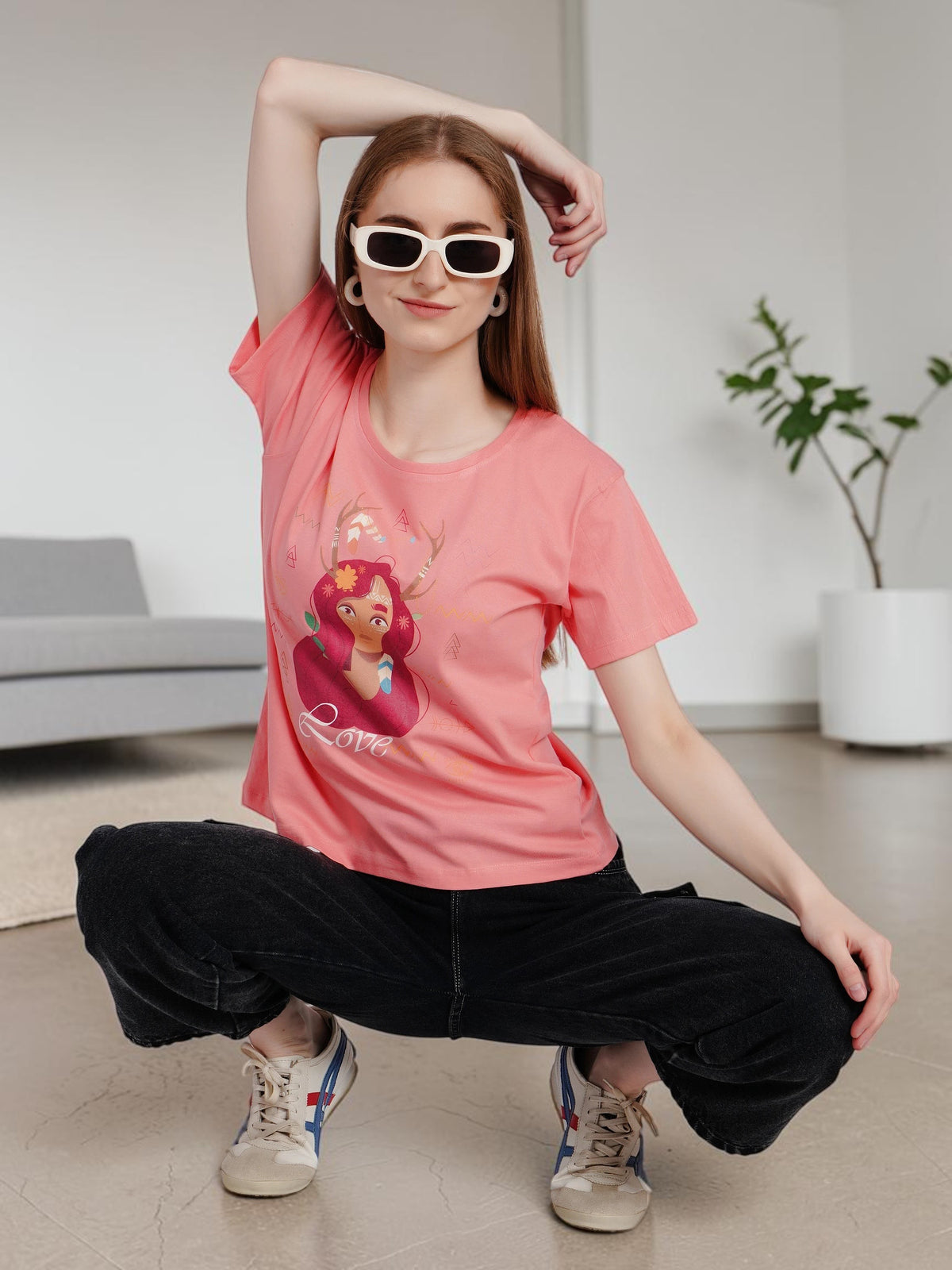 Model wearing an enaay.com peach pink cotton t-shirt with a boho girl graphic print and white sunglasses
