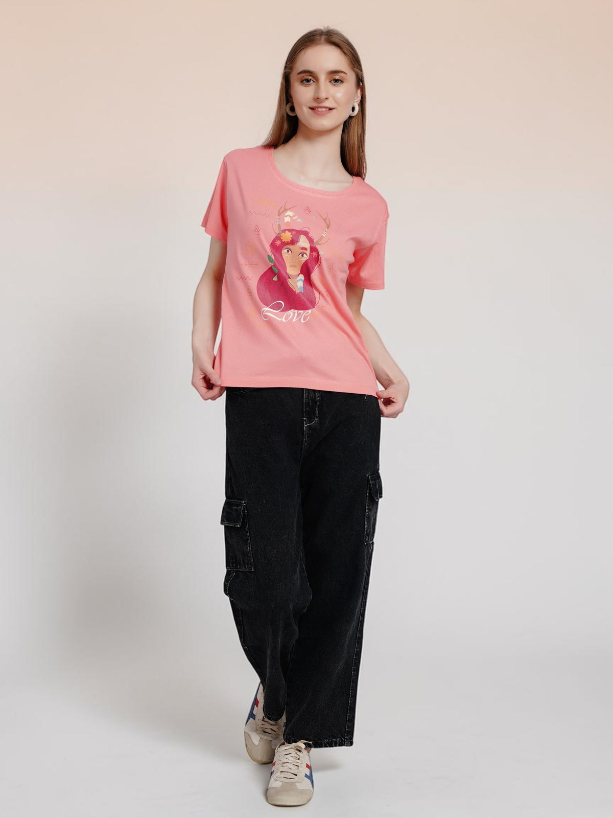 Model wearing an enaay.com peach pink cotton t-shirt with a boho girl Love graphic print and black cargo pants