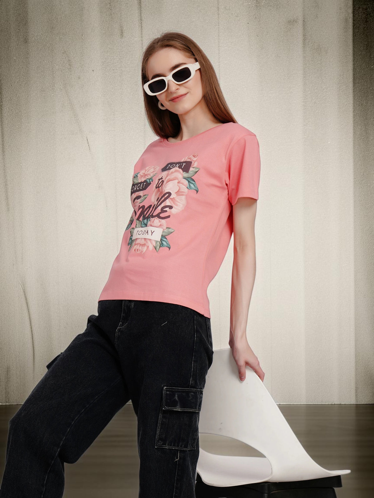 Model wearing an enaay.com pink cotton crew neck t-shirt with a floral Don't Forget To Smile Today graphic print.