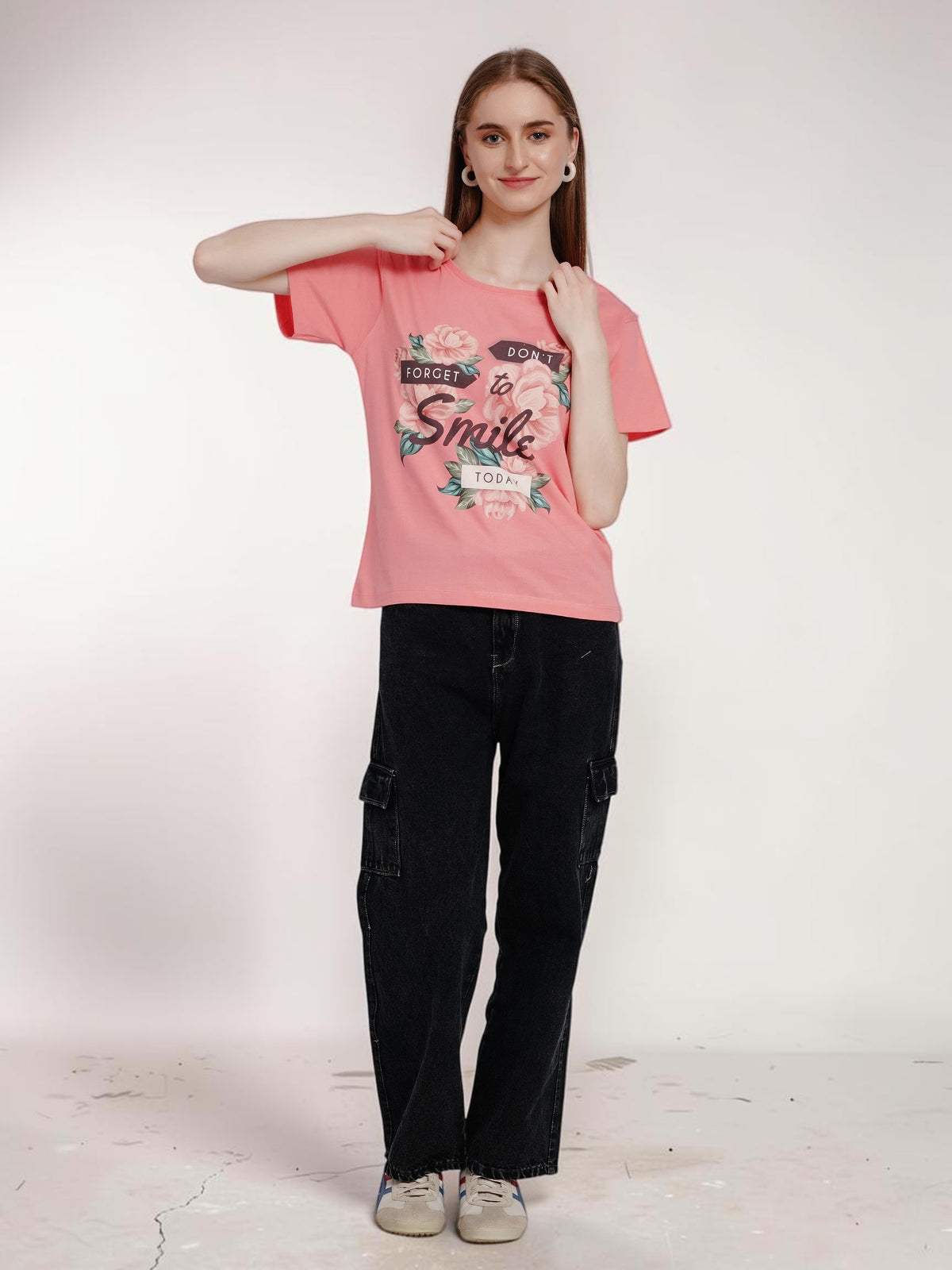 Model wearing an enaay.com pink cotton t-shirt with a floral Don't Forget To Smile Today graphic and black cargo pants