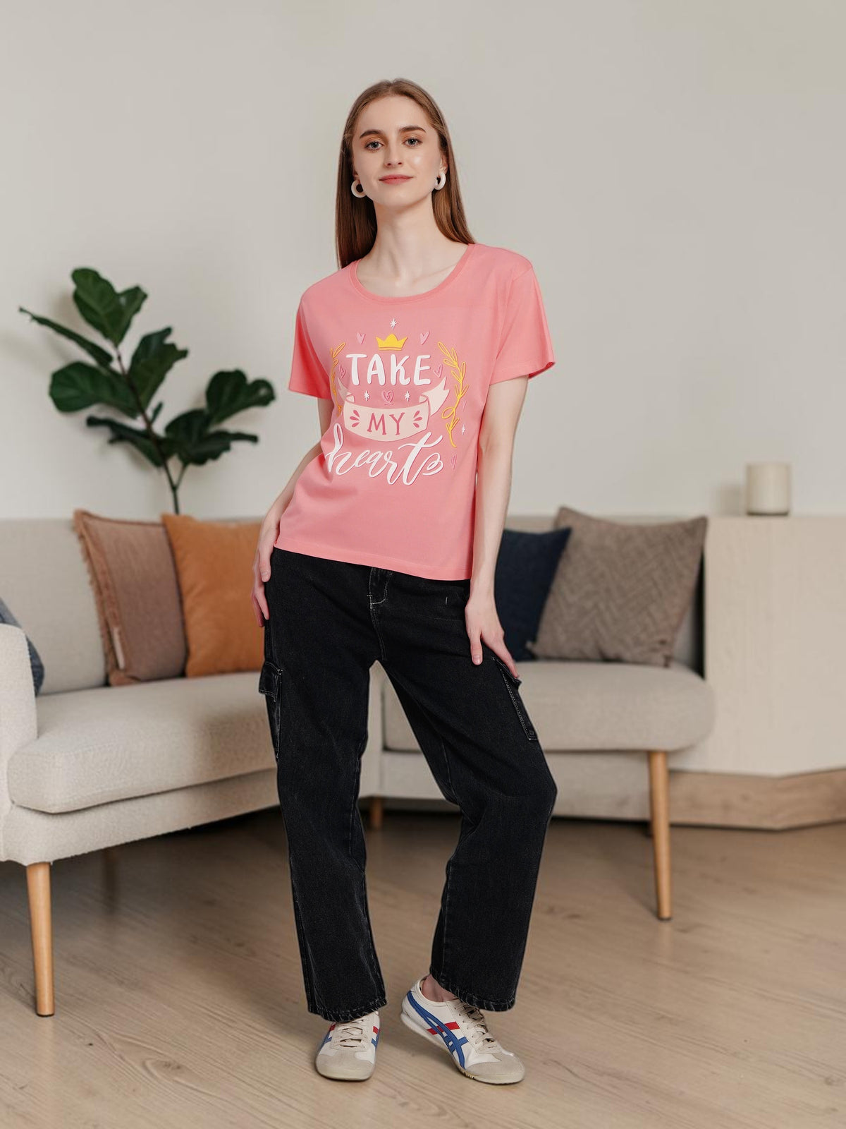 Model wearing an enaay.com coral pink cotton t-shirt with Take My Heart graphic print, styled with black cargo pants.