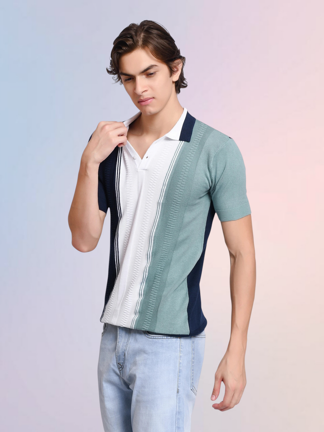 A model wearing an enaay.com navy, white, and sage green colorblock knit polo shirt with vertical pinstripe details.