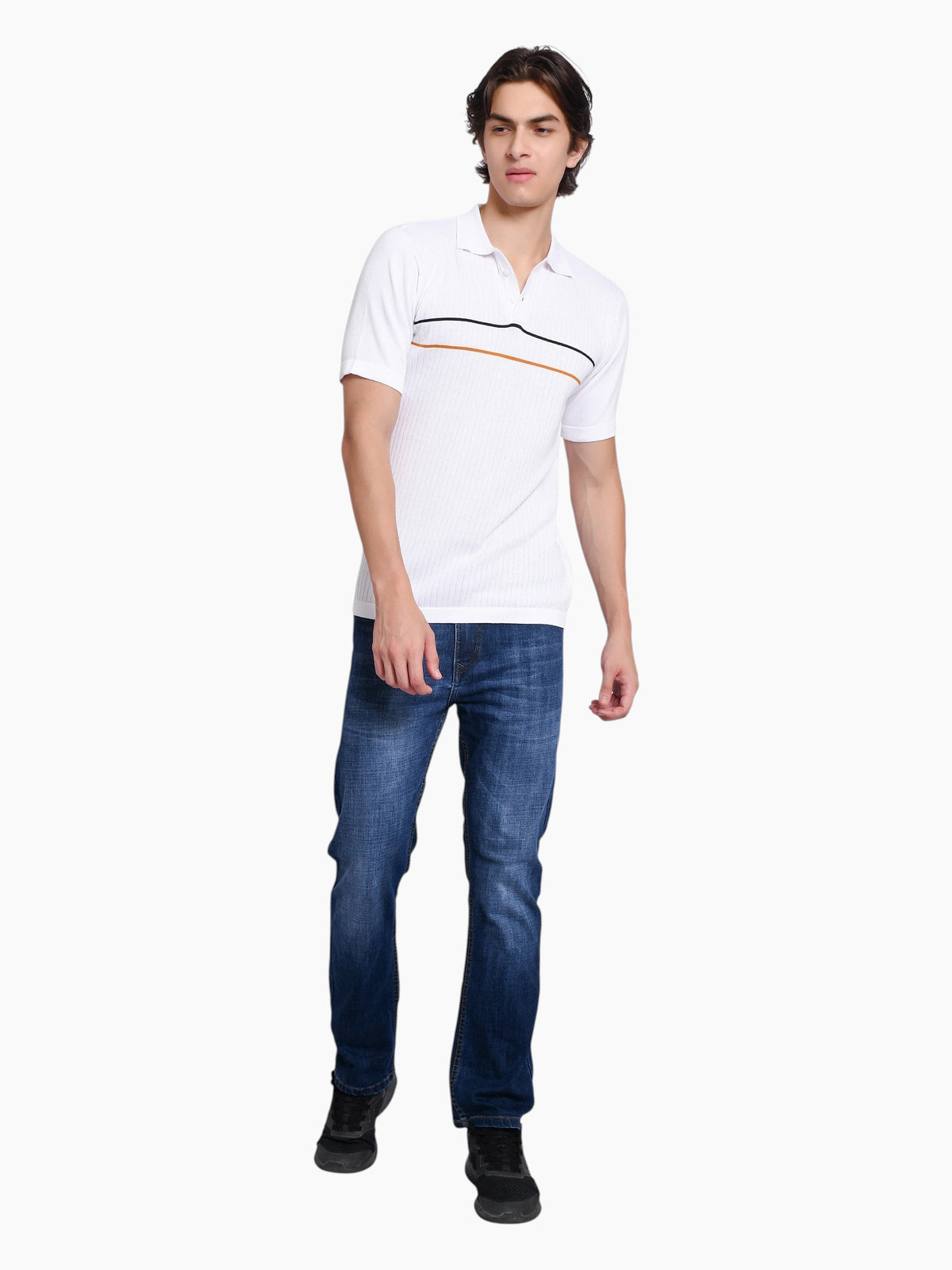 Model wearing an enaay.com white knit polo shirt with black and orange chest stripes, paired with blue denim jeans.